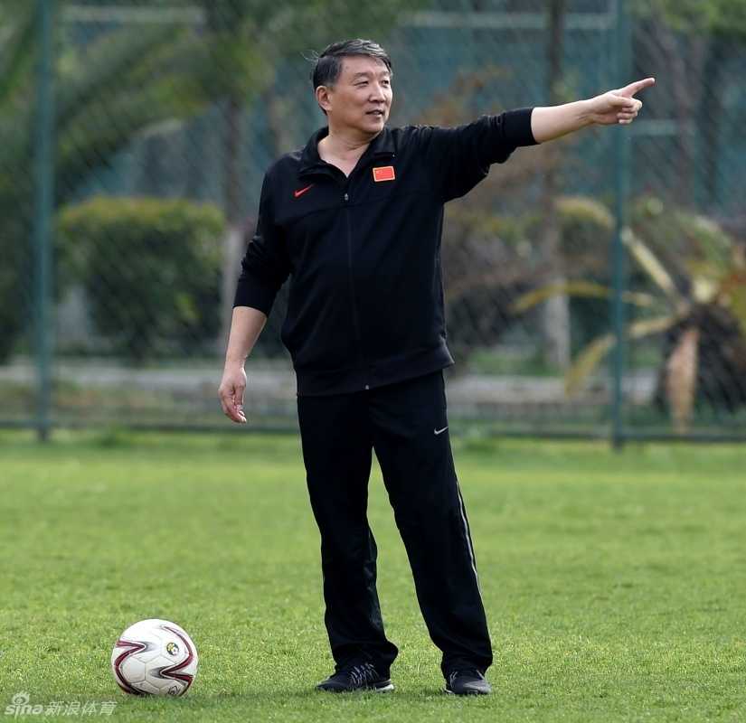 宫鲁鸣指导双手抱胸站在场边，眼神如炬紧盯着训练场上的每一次跑动，神情专注而严肃