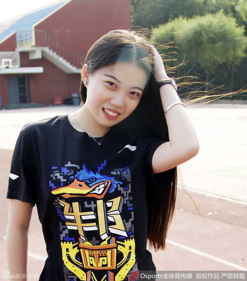 她轻松地将横幅展开，脸上挂着迷人的微笑，及腰长发在风中轻舞，大长腿的优美线条与身后北京首钢的标志相映成辉，定格下2015年这个为胜利而歌的动人瞬间。