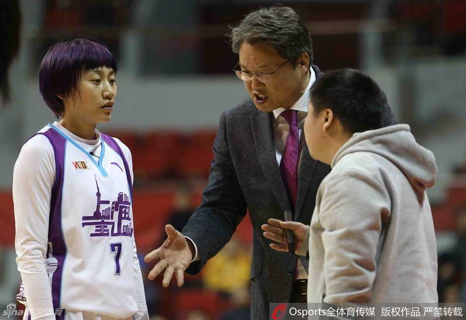 身着白色球衣的北京队员运球突破新疆队的防线，他压低重心，高速杀向内线，展现出极强的攻击欲望。