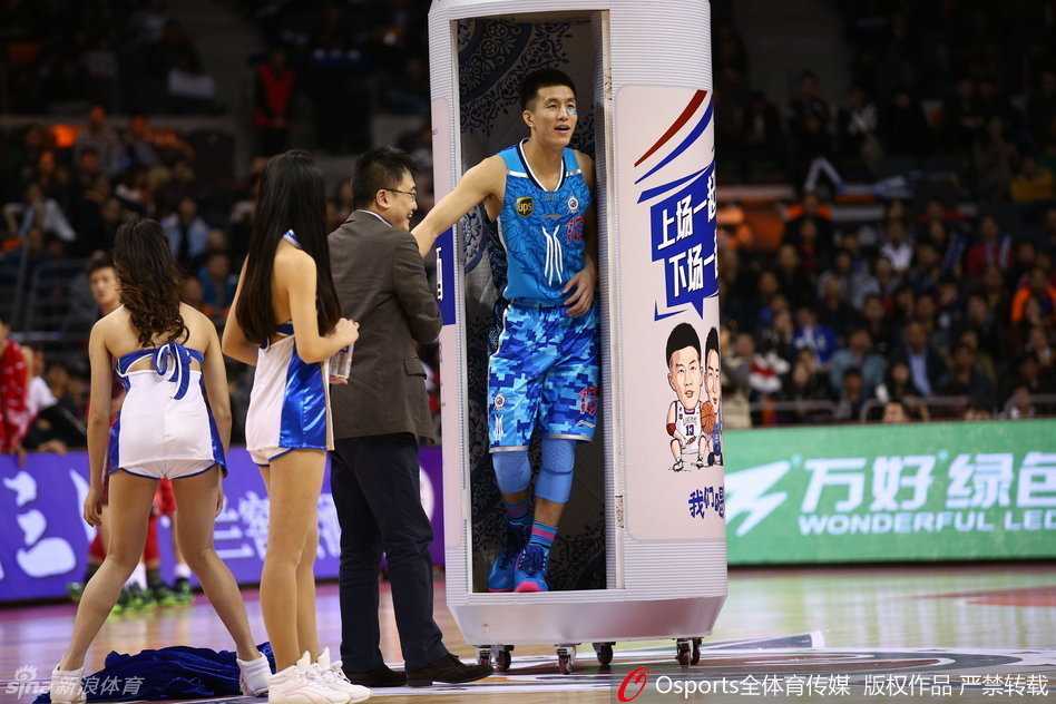 工作人员推着一个覆盖幕布的巨型装置入场，全场目光聚焦，悬念即将揭晓。