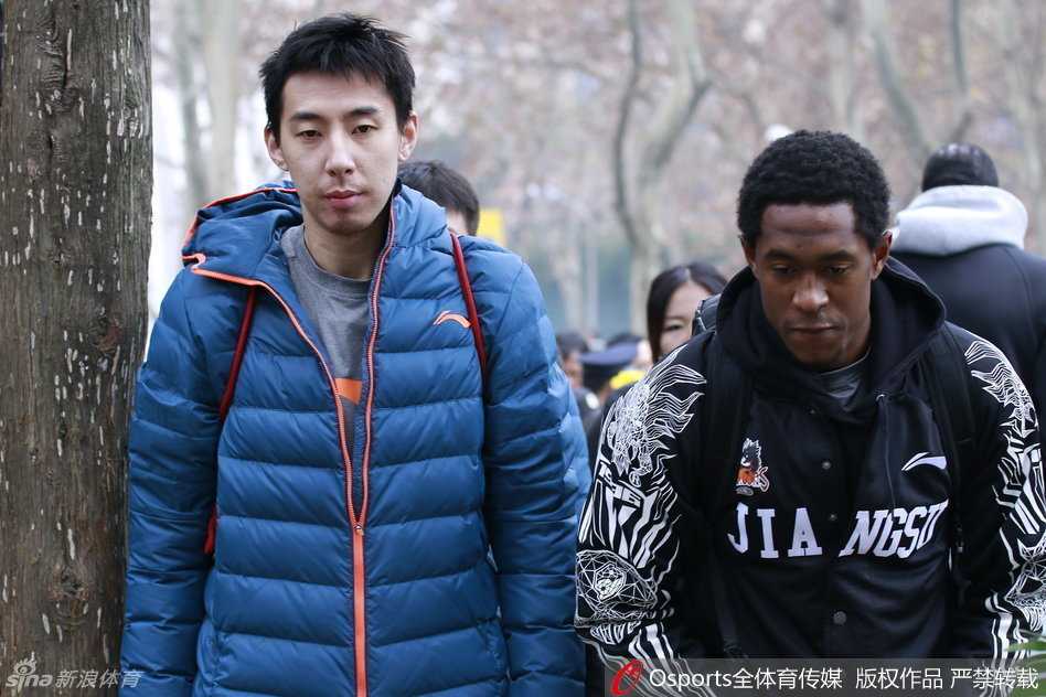 队长陈磊神情肃穆，紧抿嘴唇，他双手捧着洁白的菊花，在刻有沉重历史铭文的石碑前长久伫立，仿佛在用心倾听来自历史深处的回响。