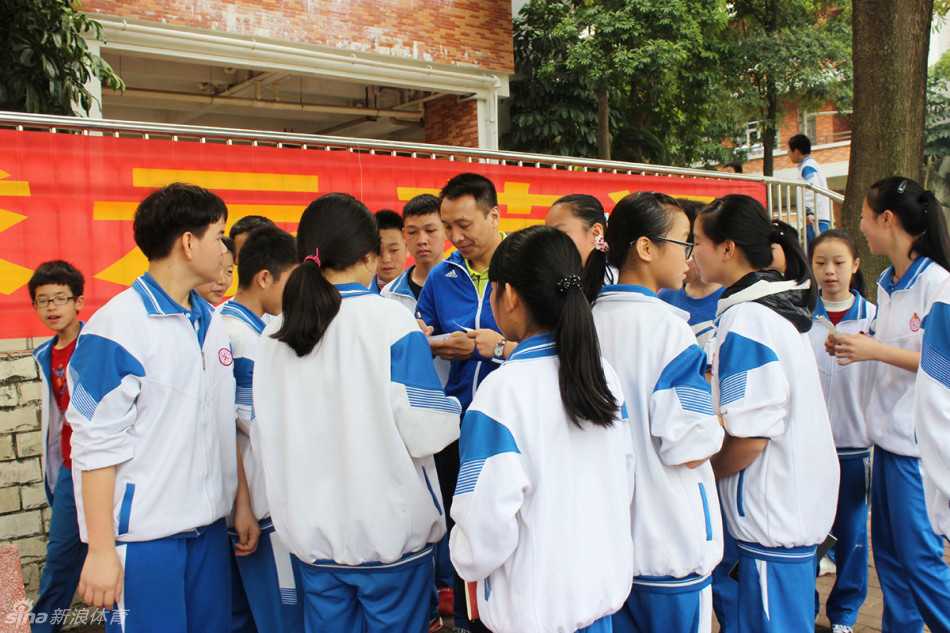 李群站在场边认真观看队员训练，脸上带着欣慰的笑容