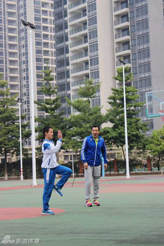 李群在篮球场上接受记者采访，神情坚定地讲述公益培训的意义