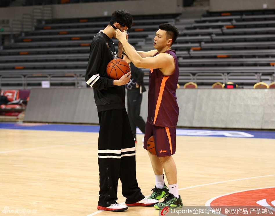 李根伸手抚摸周琦的头，周琦面带微笑，两人正在交流投篮心得
