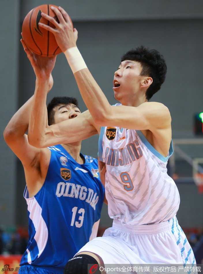 周琦在青岛队内线群中高高跃起，犹如鹤立鸡群，单手托球直送篮筐。