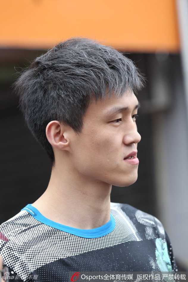 周鹏与靓丽赛车宝贝并肩合影，脸上露出轻松而腼腆的笑容