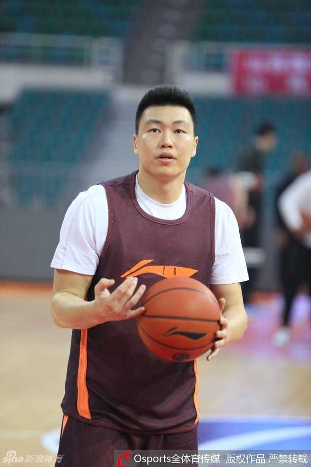 主教练李秋平手持战术板，神情严峻地给队员们讲解战术，手指在空中划出进攻路线，周琦、布莱切等人围成一圈侧耳倾听，仿佛正在接受一场战斗前的最后指令。