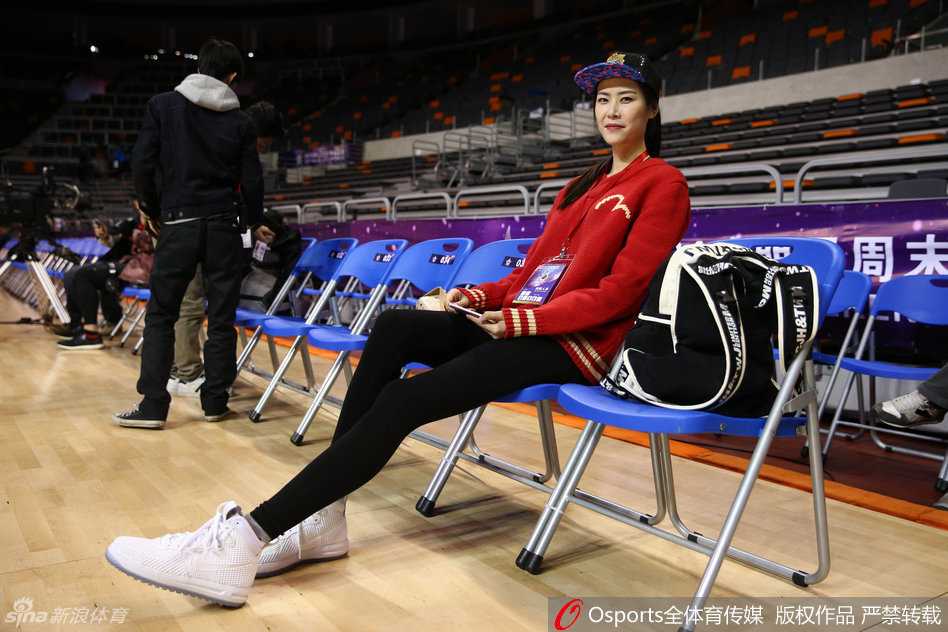 身高1米96的许诺坐在全明星赛场边，一双长腿十分抢镜，她对着镜头俏皮地比出标志性的剪刀手，笑容灿烂如花