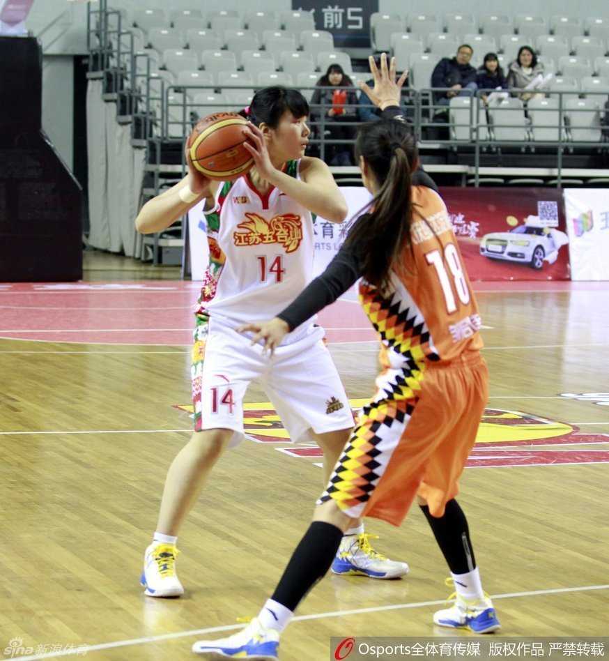 裁判员在全神贯注地观察场上局势，手势果断利落，白皙的脸庞在赛场灯光下显得格外英气逼人。