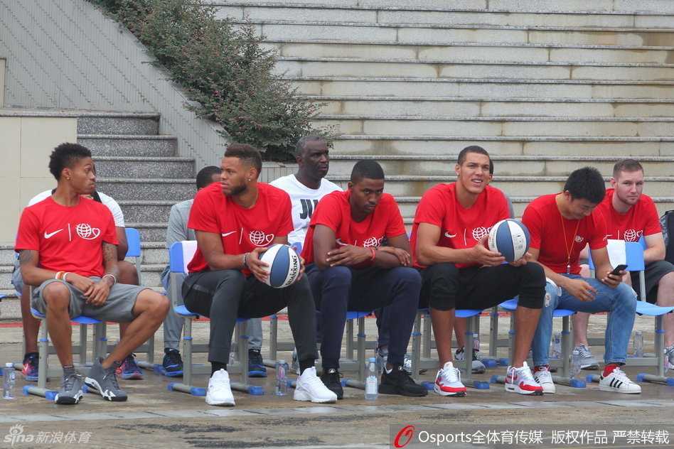 周琦俯下身子耐心指导小队员的投篮动作，眼神专注而认真，将自己的篮球技巧倾囊相授。