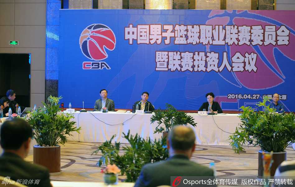 身形高大的姚明在酒店大堂内与几位熟悉的友人闲聊，他微微低头倾听，脸上露出轻松的笑容，氛围十分融洽。