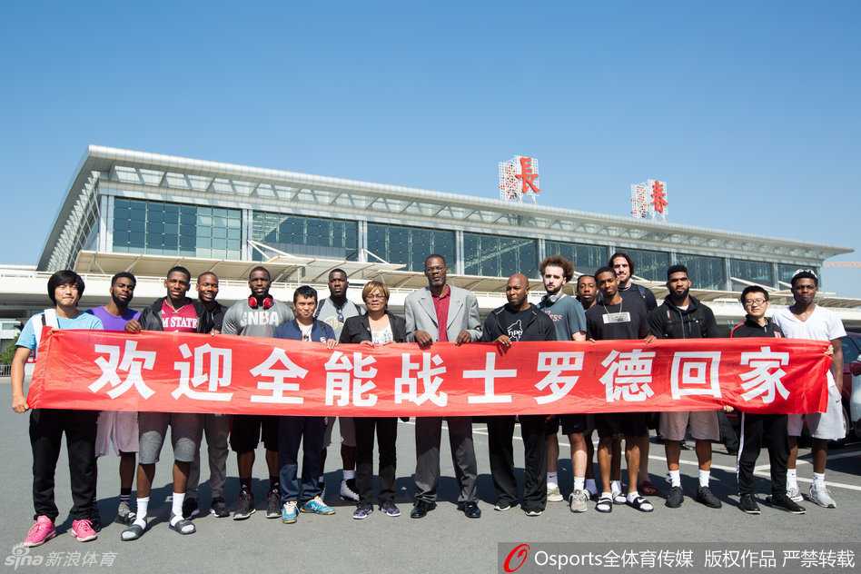 罗德被层层叠叠的记者和球迷包围在中间，他侧耳倾听提问，周围的闪光灯此起彼伏，而他的眼神中透露出回到第二故乡的安心与平静。