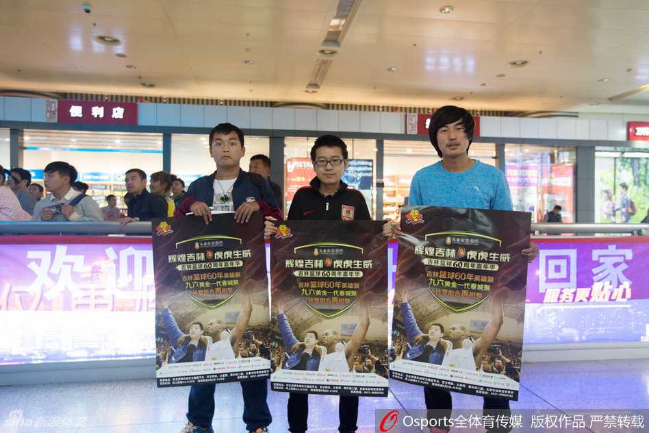 罗德将一名儿童搂在怀中，耐心地为孩子调整着球衣，孩子羞涩地摸着罗德的手臂，这画面仿佛是一种传承，象征着篮球火种的延续。