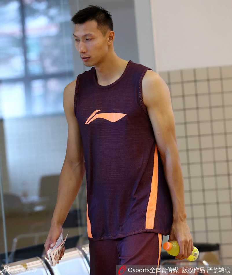 健身房的全景图，董瀚麟与多名年轻队员正在体能教练的指导下进行牵拉放松，气氛严肃而专注，墙上的宏远队徽在灯光下熠熠生辉，见证着每一份努力。