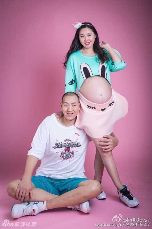 篮球巨人孙明明温柔地环抱爱妻，两人身穿休闲居家服，脸上的笑容如同午后阳光般灿烂温暖，满屏都是准父母迎接新生命的无限柔情。