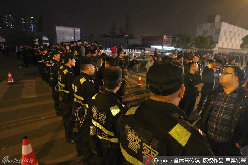 身穿黑色训练服的辽宁队球员被身穿蓝色球迷服的四川球迷围住，双方在酒店门口互相推搡，场面一度失控，一名球员正试图拉开愤怒的队友。