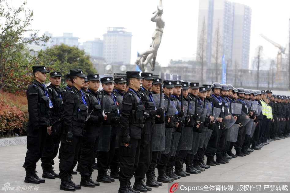 比赛开始前，一名年轻的安保人员背对喧嚣的球场，面向看台，他紧锁的眉宇间透着与年龄不符的沉稳，警惕地观察着球迷的一举一动，不放过任何一丝隐患。