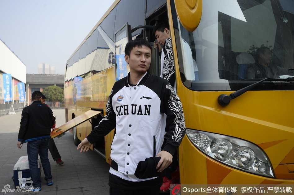 安保人员筑起人墙紧密跟随，目光如炬地守护着四川男篮最后的备战时光，背景中球员的身影显得格外从容与坚定。