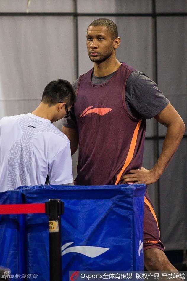 主教练闵鹿蕾在场边接受媒体采访，他表情严肃认真，手里拿着战术板，正对着镜头分析球队的夏训计划。