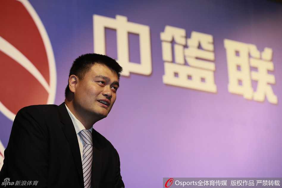 身高2米26的姚明如同灯塔般矗立在人群中央，媒体的长枪短炮将他层层包围，哪怕是在如此拥挤的环境中，他依然保持着绅士风度，耐心回应着每一个提问。