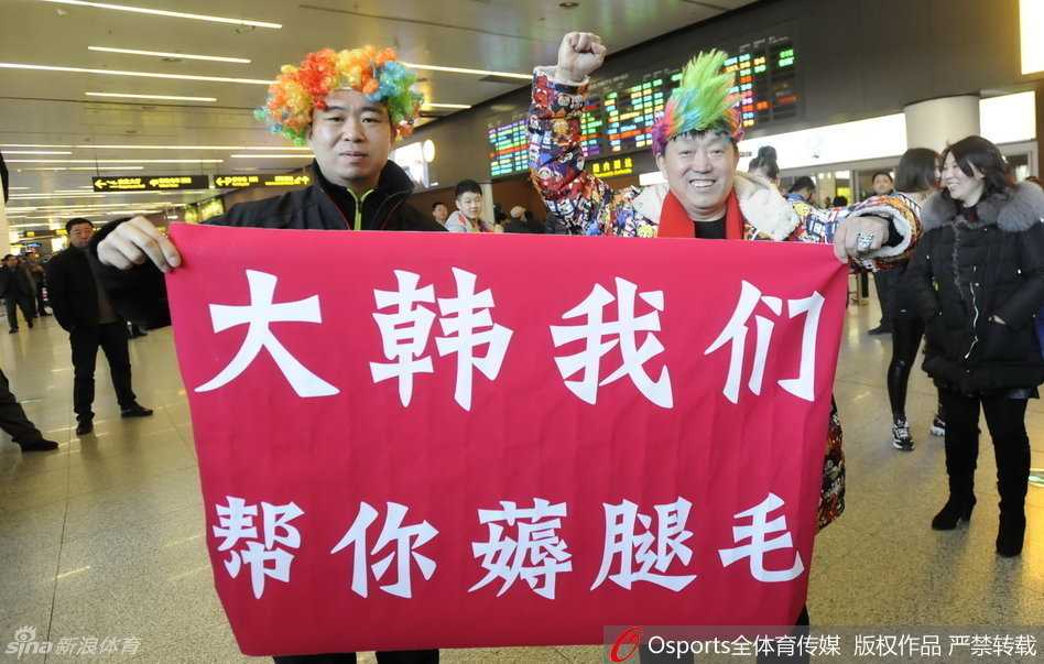 机场到达大厅内人山人海，到处都是身穿红色助威T恤的辽宁球迷，他们高举着手机和标语牌，目光聚焦于同一个方向，整个大厅被这种狂热而又充满敬意的氛围所填满。