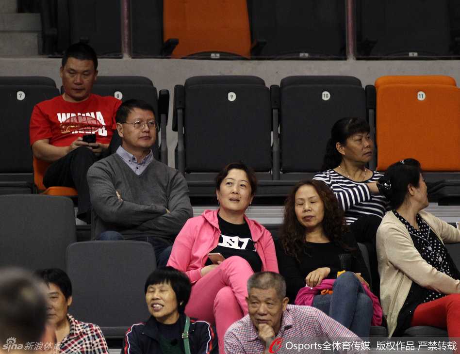 易建联用球衣遮住面部，难掩激动之情，身后是呼啸而过的赛场和热情的球迷。