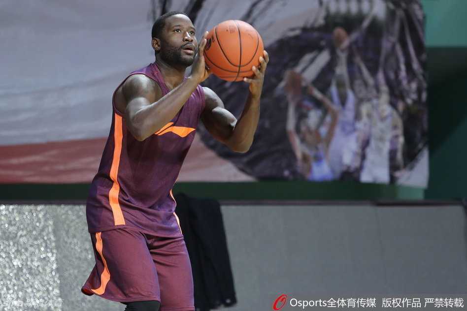 广东队组织核心斯隆在赛前训练中专注跳投，篮球划过球场上空的优美弧线。