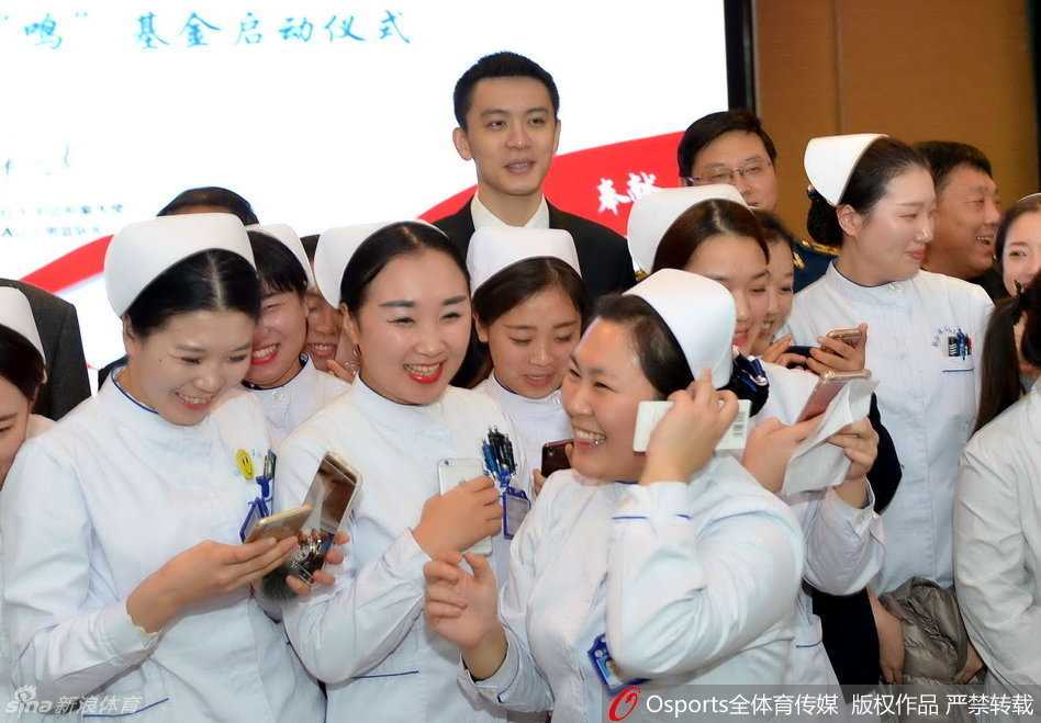 杨鸣被热情的护士姐姐们集体围住，他笑容温暖，耐心与大家互动合影