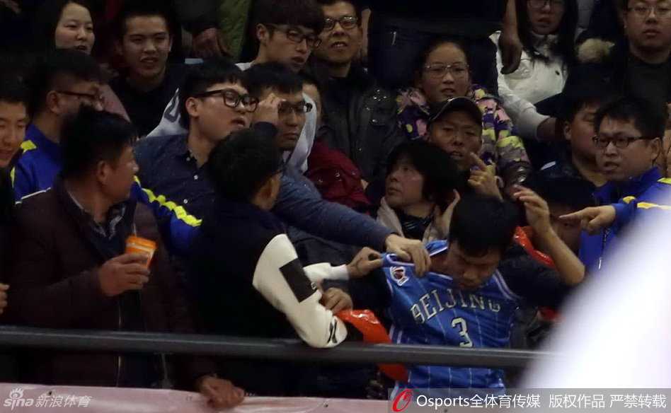 几位身穿北京队球衣的球迷误入江苏队主场看台，立即被主队球迷团团围住，双方情绪激动，相互推搡指责，现场火药味十足
