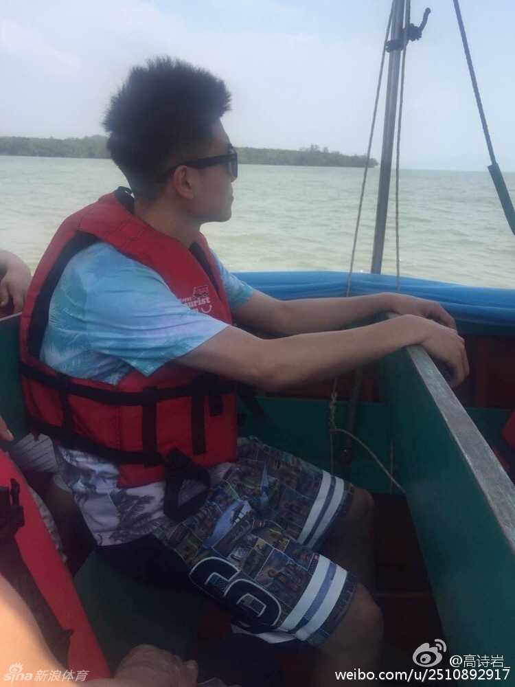 高诗岩与父亲并肩坐在小船上，两人手握船桨，脸上洋溢着轻松惬意的笑容，享受着海面上的亲子时光