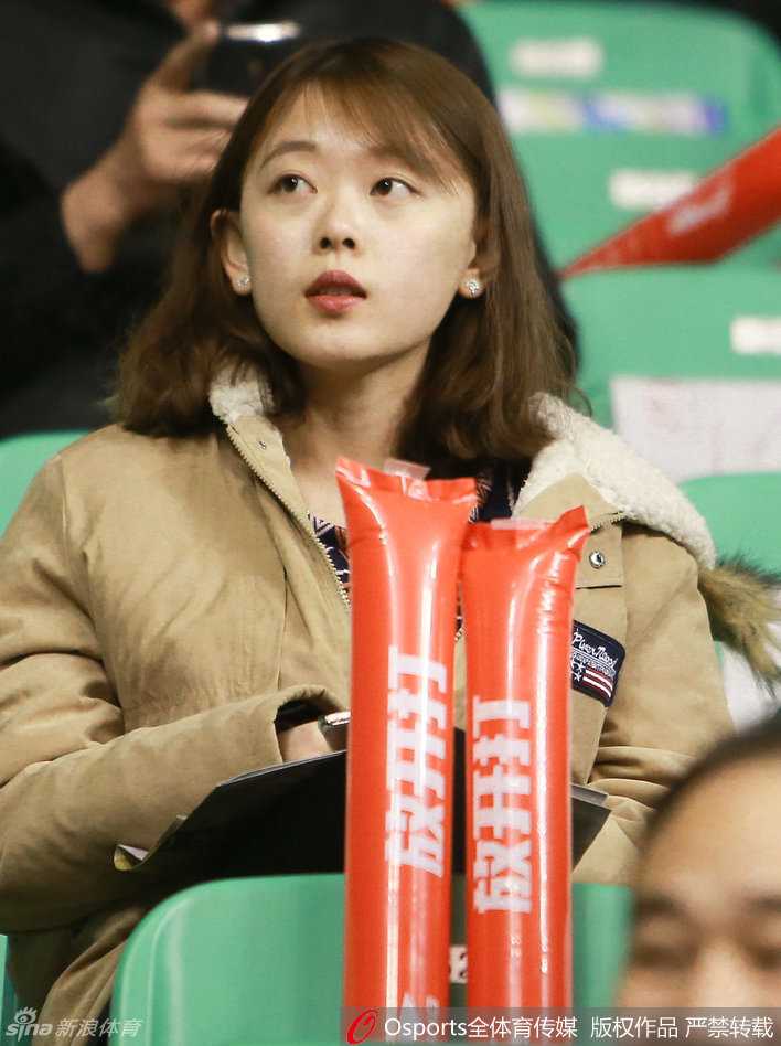 中场休息时，一位戴着棒球帽的美女球迷似乎察觉到了镜头的存在，下意识地用手整理着帽檐，动作中带着一丝少女的羞涩与俏皮。