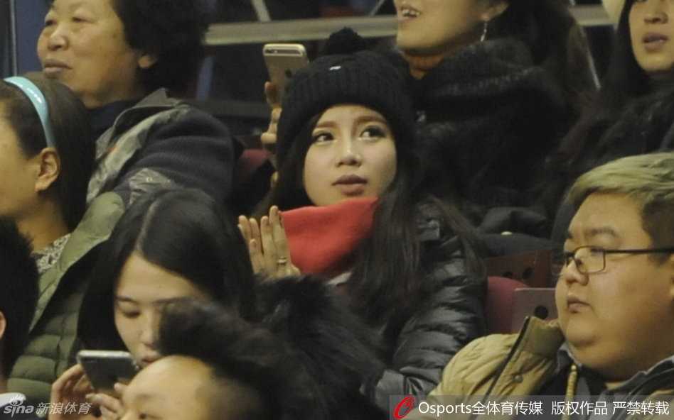 王俪婷举起手机，试图记录下郭艾伦在场上的精彩瞬间，她的脸上写满了对男友的崇拜与爱意，仿佛要将这些拼搏的时刻永久珍藏。