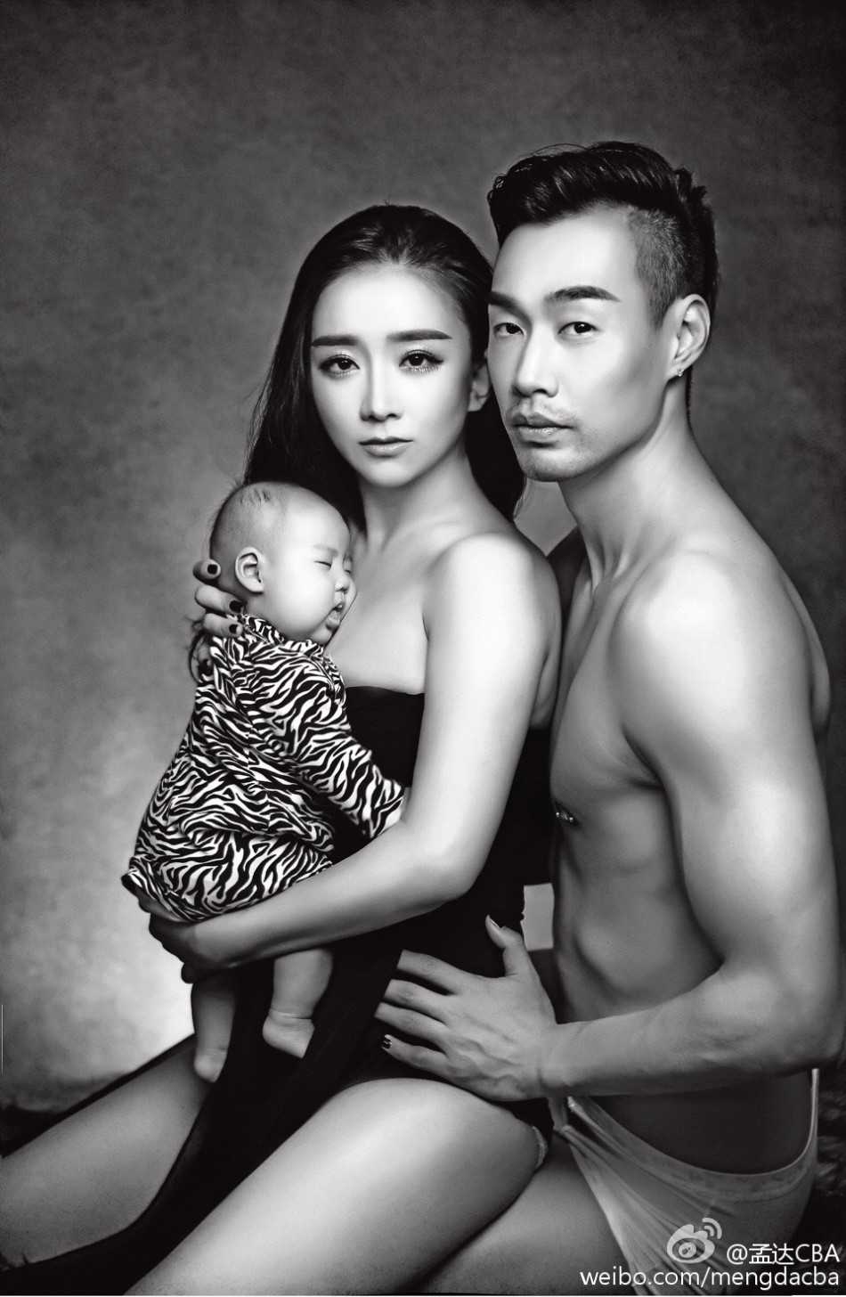 妈妈身穿休闲装展现迷人曲线，抱着孩子眺望远方，画面充满温馨的母爱与时尚韵味