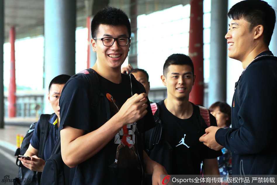 锋线尖刀李根现身机场，面对接机人群露出轻松笑容，身背行囊步伐矫健，仿佛对即将到来的恶战早已胸有成竹。