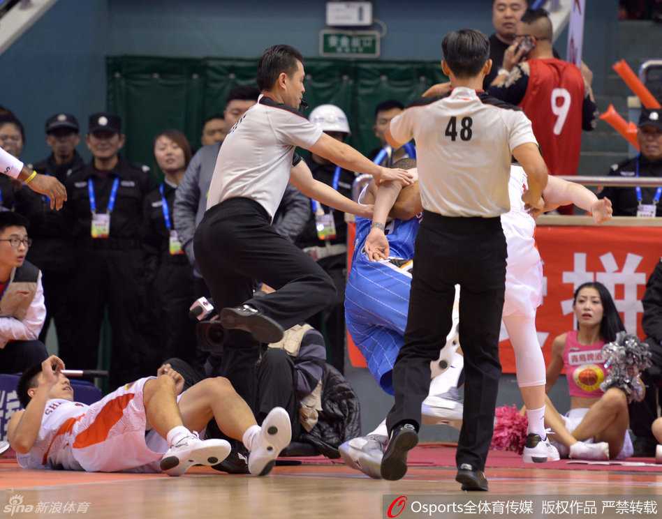 裁判果断介入，张开双臂奋力隔开双方球员，试图平息这场一触即发的暴力冲突，成为场上唯一的冷静者。