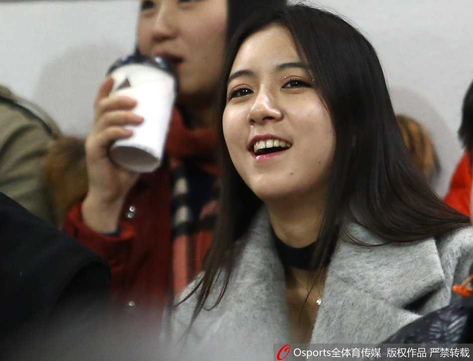 女球迷赛后腼腆接受采访，长发微扬，笑容温暖如春日阳光