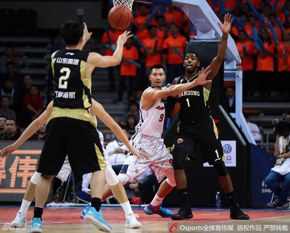 身穿红色战袍的易建联在山东外援贾森-汤普森的紧逼下，眼神坚毅地持球准备进攻，两人肌肉碰撞的瞬间充满了力量感