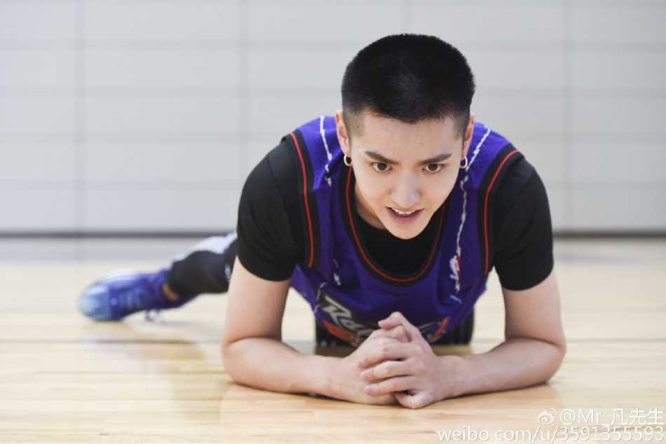 吴亦凡在阳光下跃起投篮，身体线条舒展优美，篮球在空中划出完美弧线，专注的眼神紧盯着篮筐，仿佛整个世界都静止在这一刻。