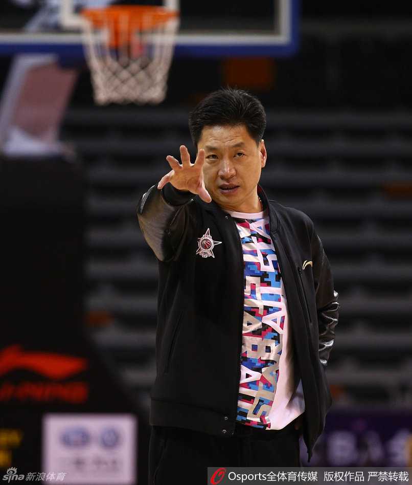 南区队主教练李春江在训练中神情严肃地指导队员，对战术细节要求极高，尽显冠军教头风范。