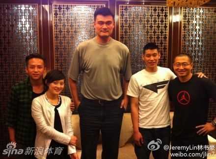 丁俊晖与魔术师刘谦现场互动，刘谦手拿扑克牌，丁俊晖好奇观看，马云、施瓦辛格、潘石屹在旁微笑围观。