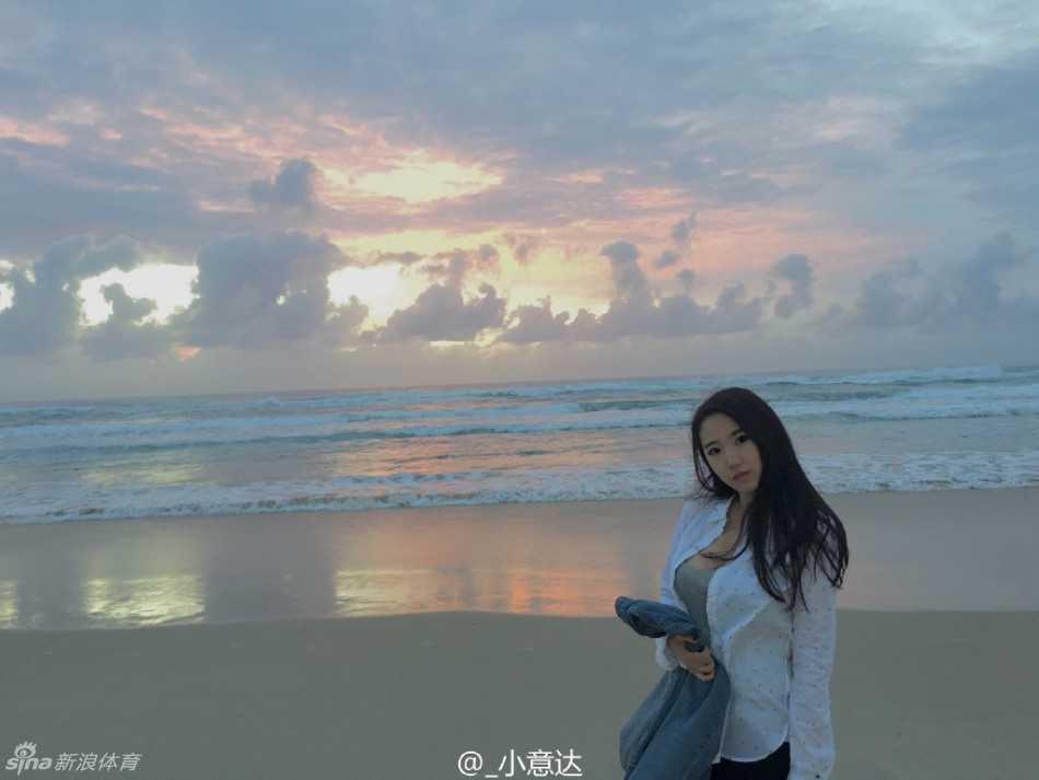 画面定格在一个甜蜜的瞬间，女孩对着镜头俏皮地眨眼，白皙的肌肤在阳光下透着健康的红晕，身后的棕榈树更添几分热带风情。