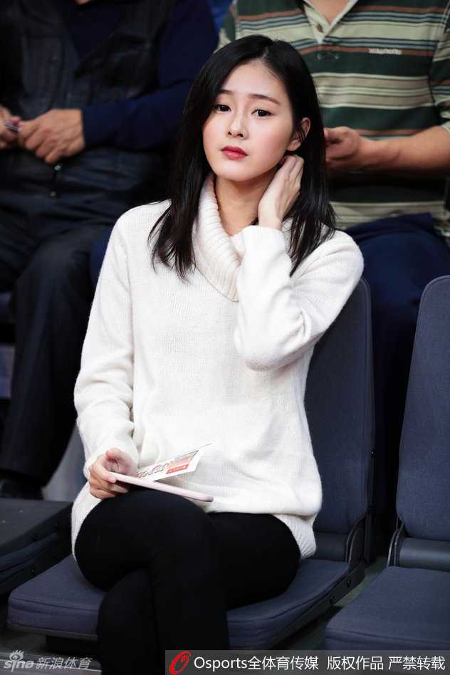 这位女球迷在广东队进攻得手后振臂欢呼，随性的白色T恤挡不住出众的气质，肤白貌美与热血篮球相得益彰。