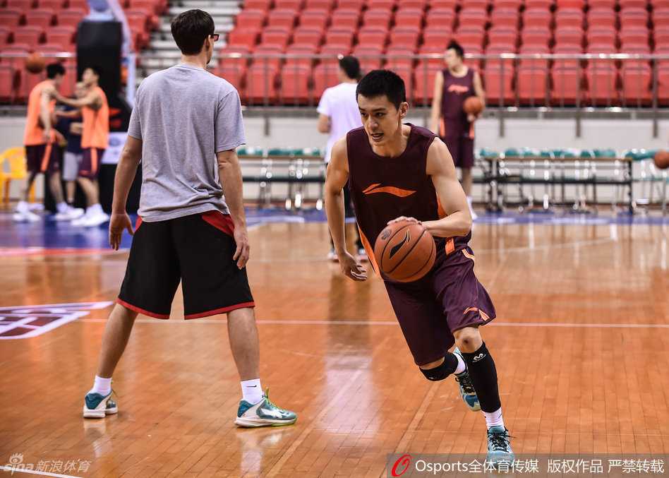 队长杨鸣在训练中神情严肃，举手示意战术跑位，作为球场大脑的他正耐心梳理着球队的攻防节奏