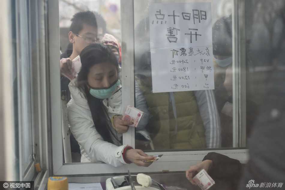 售票窗口前，一位成功购得球票的球迷抑制不住内心的激动，高高举起手中的信封，仿佛举起了整个世界的希望，那份喜悦感染了在场的每一个人。