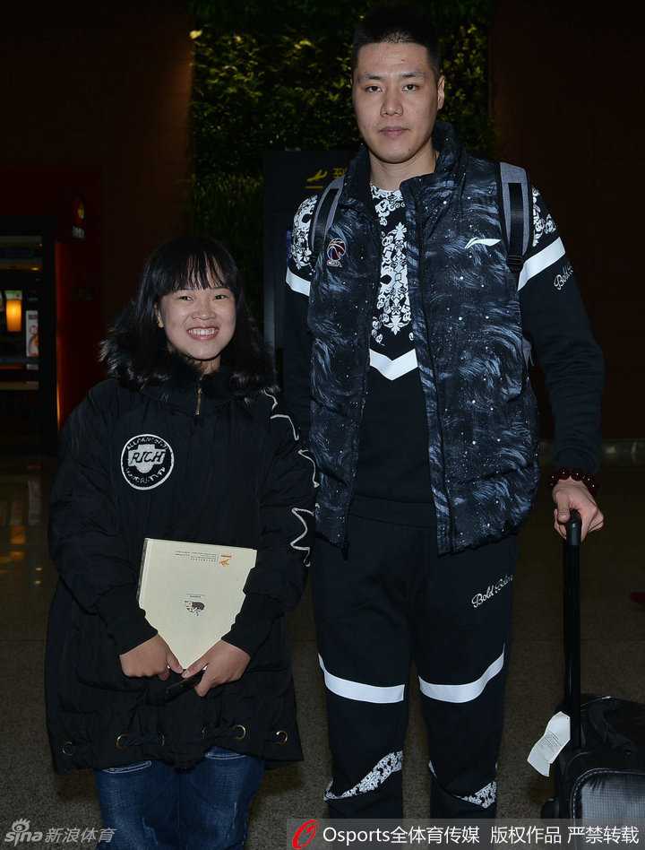 队长杨鸣被热情的女球迷团团围住，他耐心地低头签名，俊朗侧颜与温暖笑容引发现场尖叫