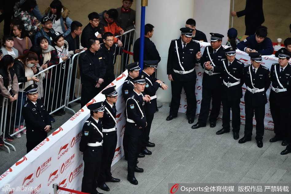 场馆外安保人员手拉手组成人墙，全力维持秩序，背景是热情等待的辽宁球迷