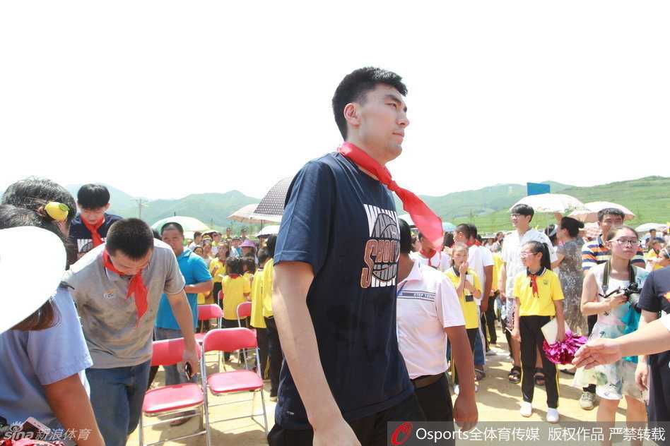 在简易的会场上，郭士强端坐在椅子上，双手交握，认真倾听着校方代表介绍学校体育教育的情况，眼神中充满关切。