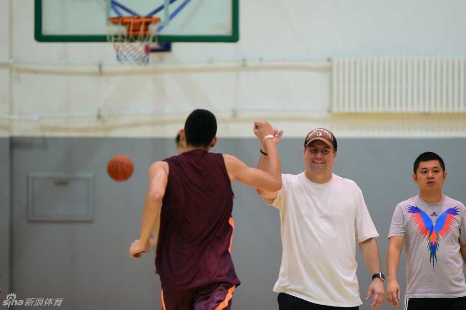 激情主帅邓华德在训练场上与年轻队员用力击掌，他的脸上挂着标志性的灿烂笑容，仿佛要将必胜的信念通过掌心传递给每一位东北虎将士。