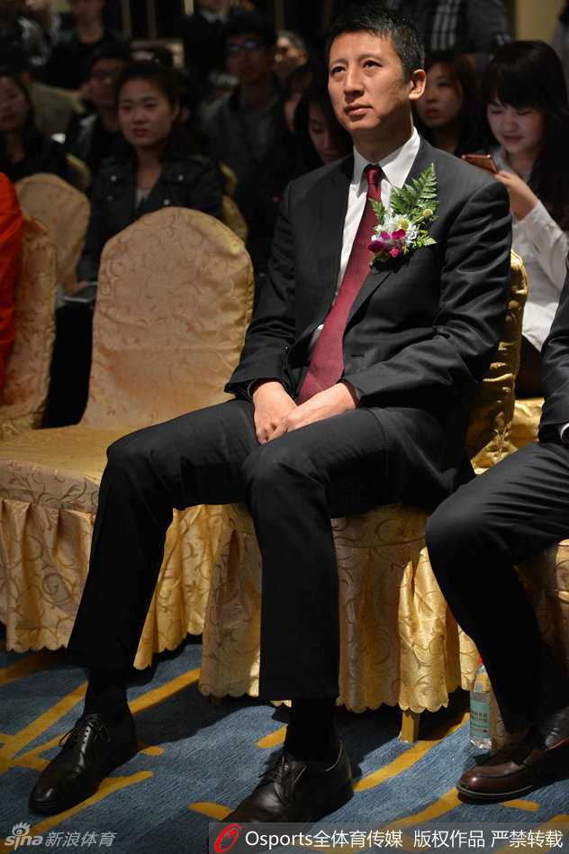 郭士强与辽篮球迷的那些暖心瞬间 从赛场内到校园中的真情互动 活动现场气氛热烈,郭士强被一群穿着红色T恤的年轻球迷簇拥在中间,他手持签字笔,正侧身倾听一位球迷的提问