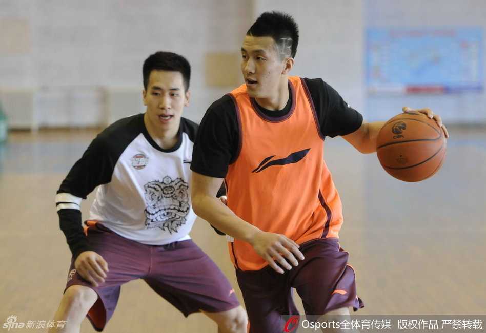 郭爸在训练中客串组织者，他双手稳稳持球，眼神犀利，正在给年轻球员们做传球示范。